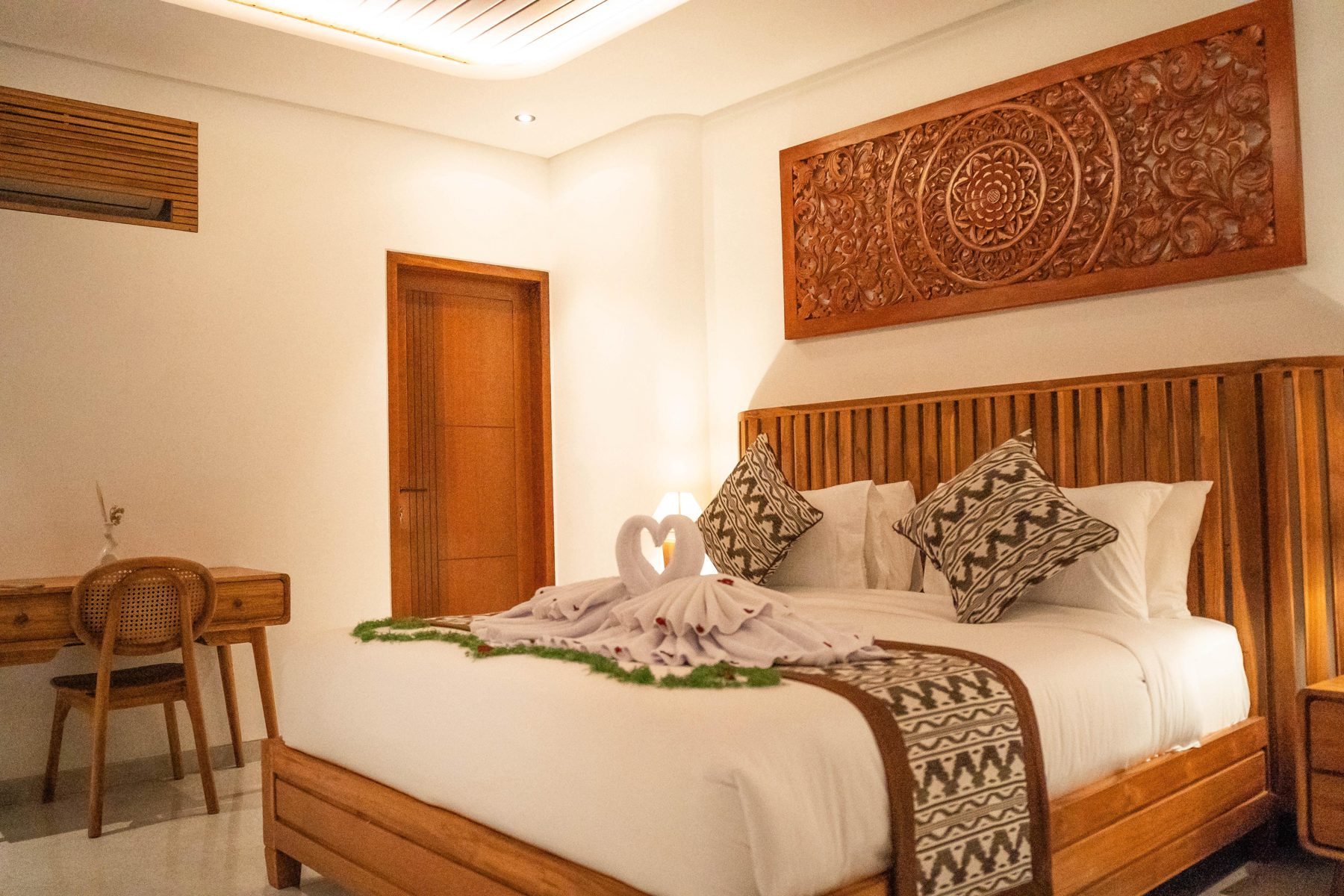 Bedroom with carved teak headboard and desk